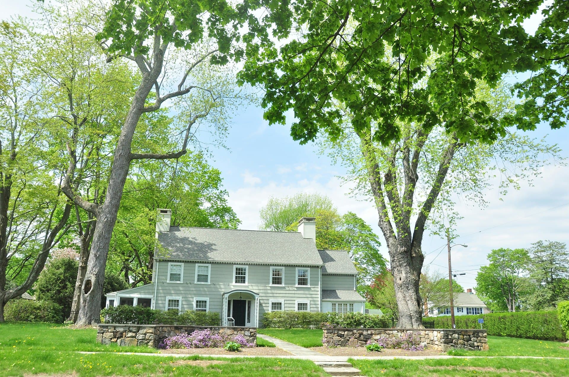 Colonial home framed by mature trees in Northern New York